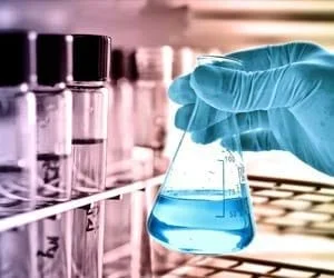 Close-up of scientist’s hand with rubber glove using chemicals in a laboratory