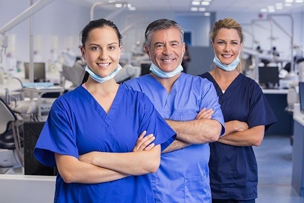 Large group of iaomt dentists and assistants standing in a circle giving a high five